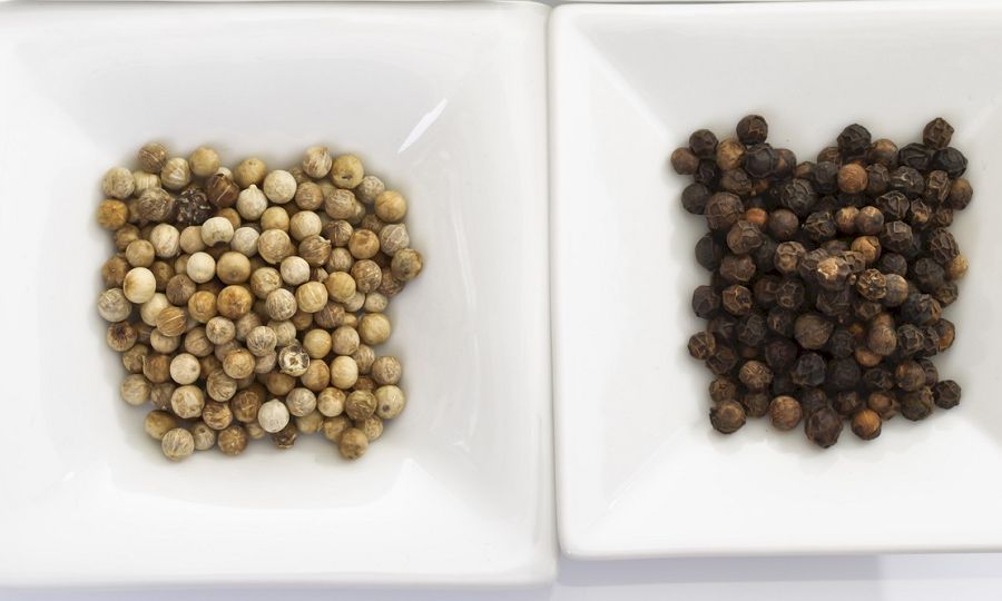 Different spices, red, green, white and black pepper in bowls
