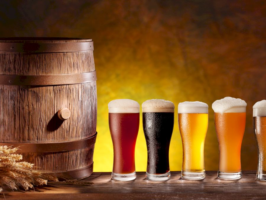 Beer glasses with a wooden barrel. Background - dark yellow gradient.