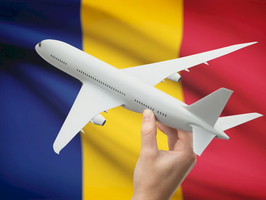 Airplane in hand with flag on background - Romania