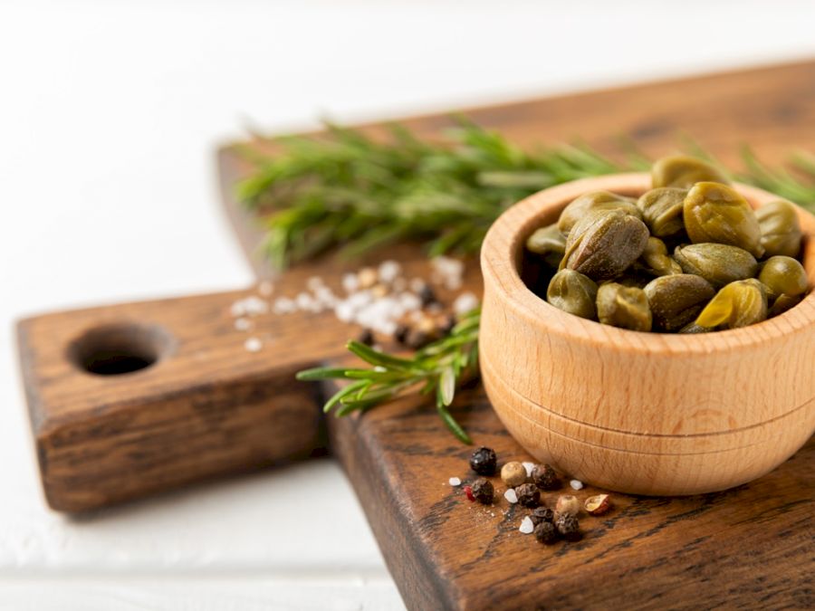 Capers,In,A,Bowl,On,A,Wooden,Kitchen,Table.,Capers